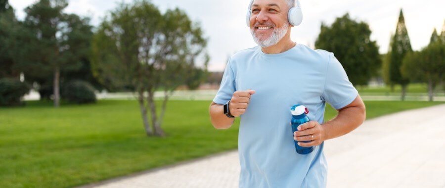 Man improving his heart health by running and listening to music