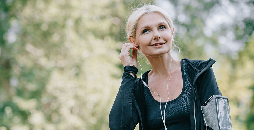 Recovering gut health patient listens to a podcast while exercising outdoors.