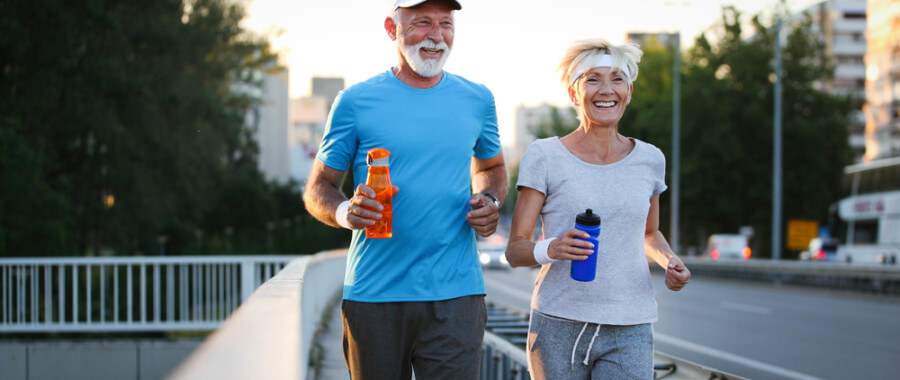Healthy older couple jogging in city with healthy hormones and osteoporosis